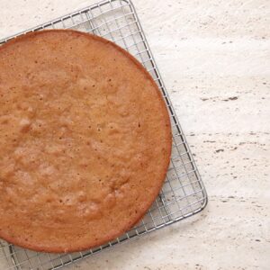 Flat lay food - a freshly made coffee sponge cake cooling on a wire rack